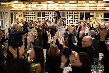 A woman in a white dress is dancing in front of a crowd