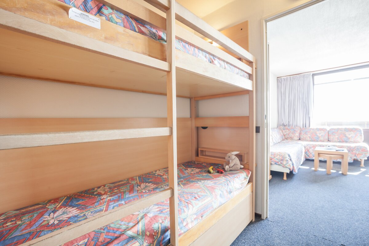 A room with bunk beds and a couch and a sign on the wall