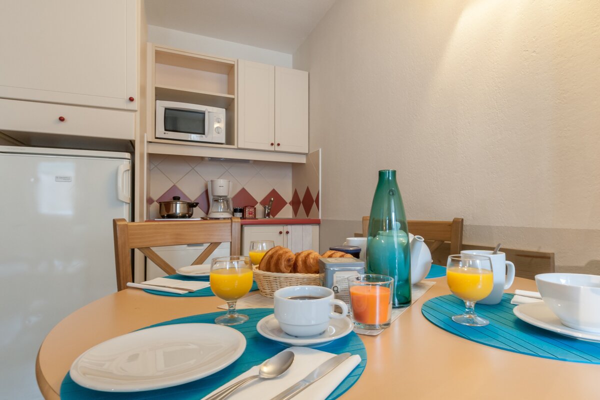 A table with plates and glasses of orange juice on it