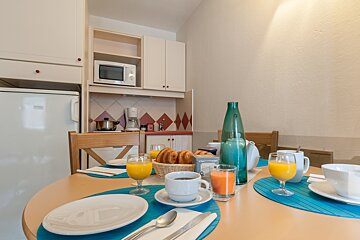 A table with plates and glasses of orange juice on it