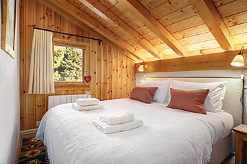 A bedroom with a king size bed and a window