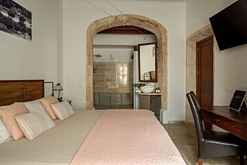 A hotel room with a bed and a desk with a sign that says ' hotel ' on it
