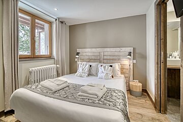 A bedroom with a large bed and a window