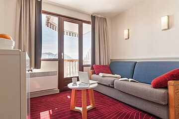 A living room with a couch and a table with a laptop on it