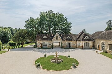 A large house with a fountain in front of it