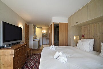 A bedroom with two beds and a flat screen tv
