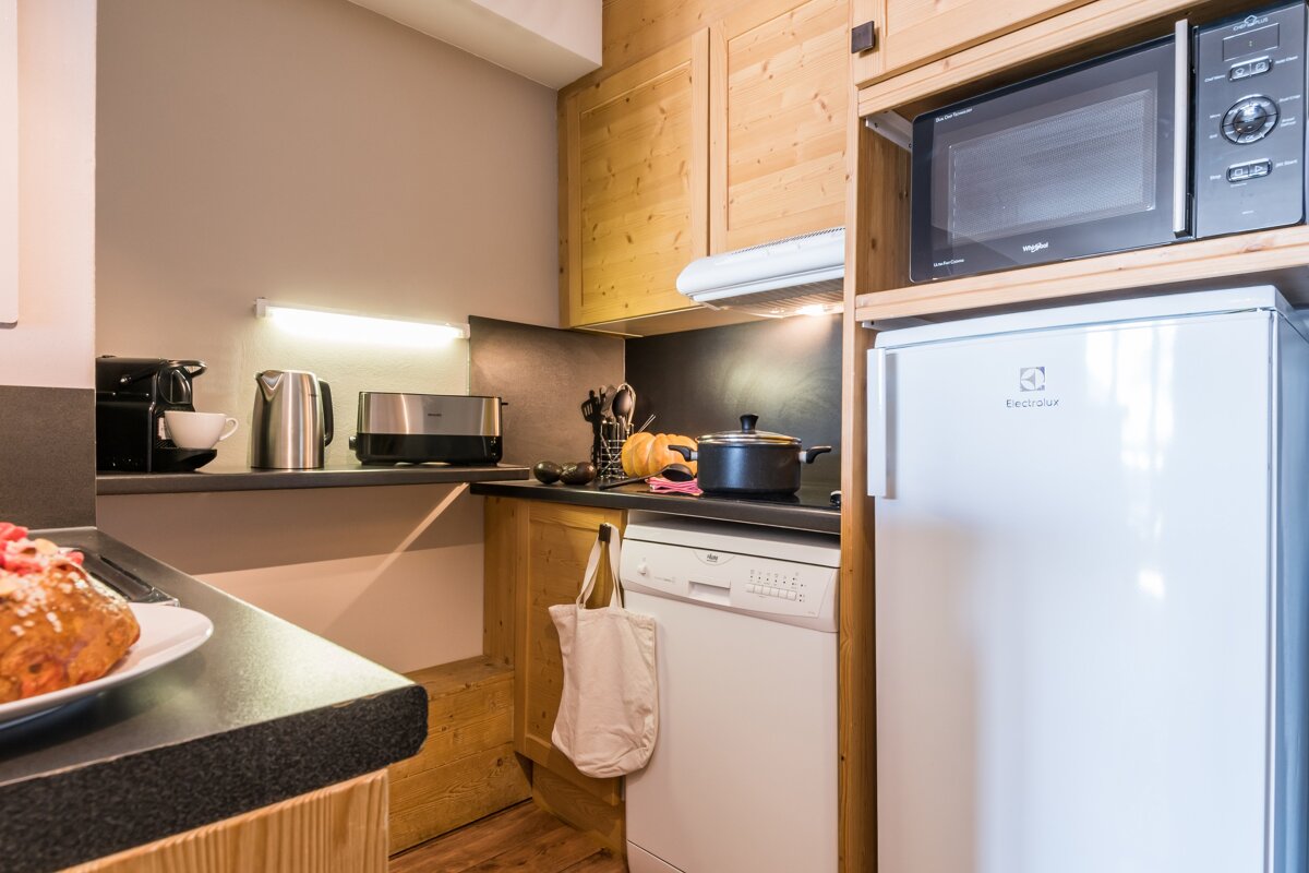 A kitchen with an electrolux refrigerator and a whirlpool microwave
