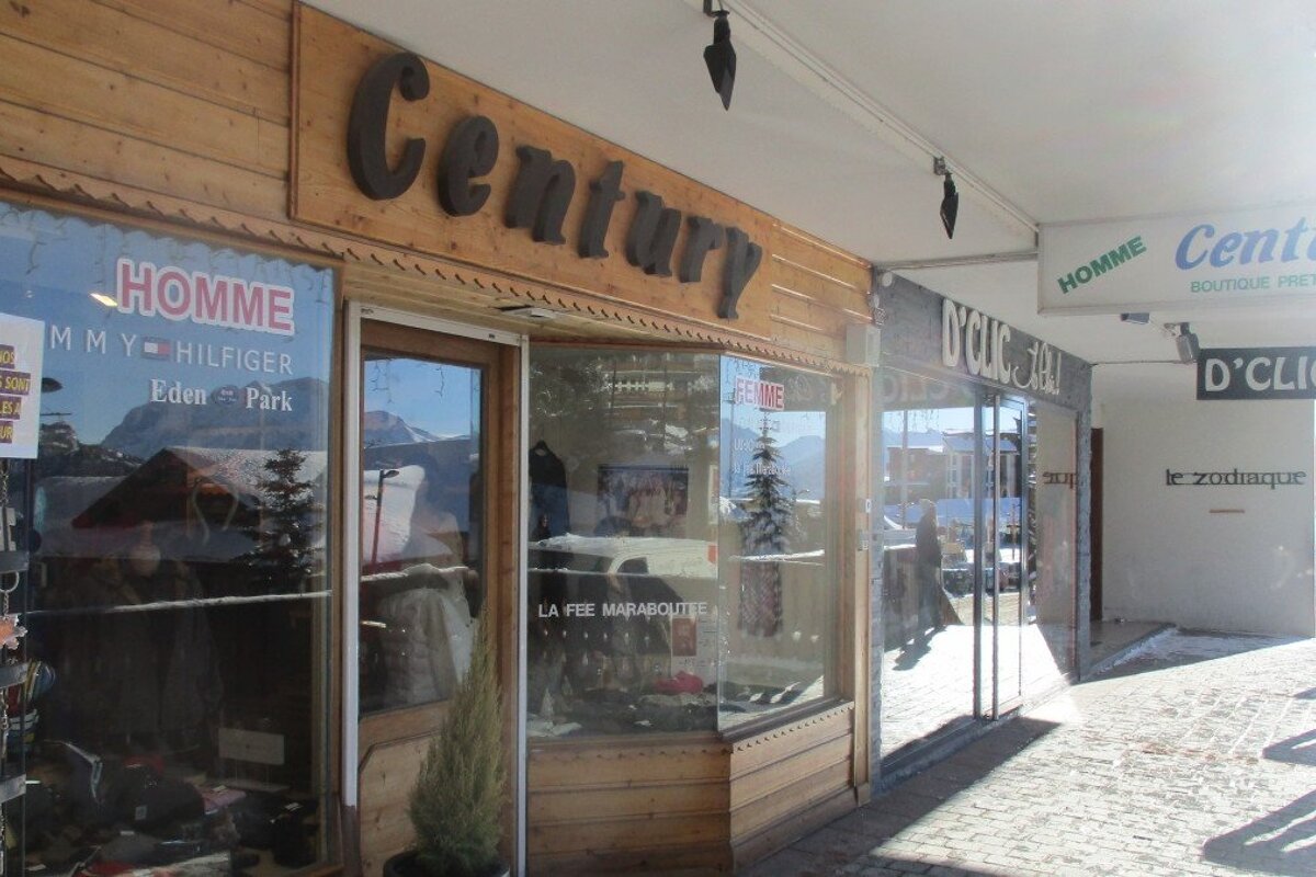 a shop front with a wooden sign in alpe dhuez
