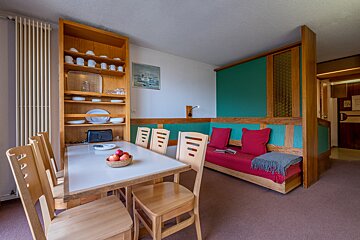A living room with a dining table and chairs