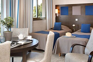 A hotel room with two beds and a table