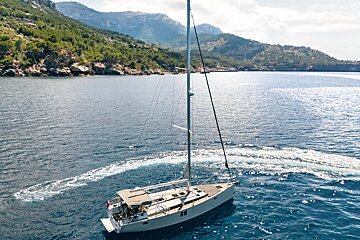 A sailboat in the ocean with mountains in the background