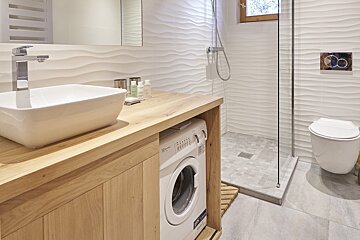 A bathroom with a washing machine and a sink