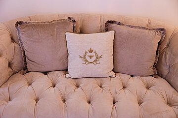 A pillow with a crown on it sits on a couch