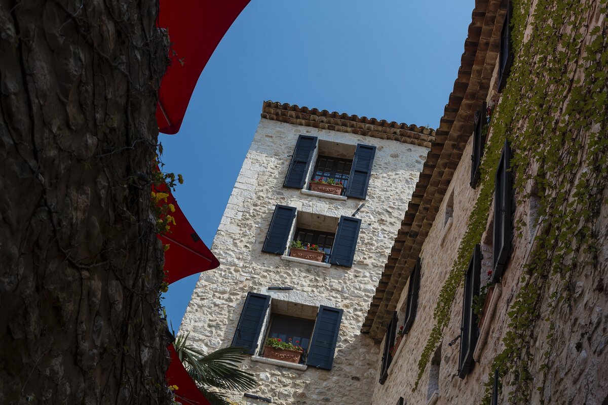 Looking up at a stone building with black shutters