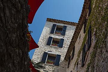 Looking up at a stone building with black shutters