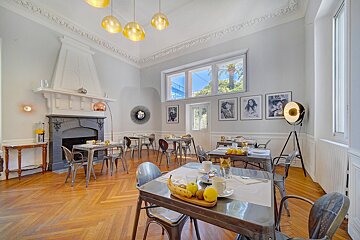 A dining room with tables and chairs and a fireplace