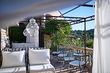 A balcony with white furniture and a canopy over it