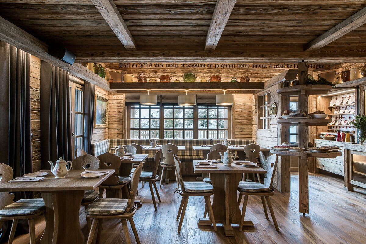 A dining room with wooden tables and chairs and a sign on the ceiling