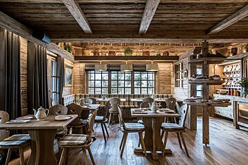 A dining room with wooden tables and chairs and a sign on the ceiling
