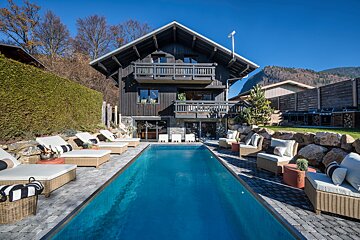 A large house with a swimming pool in front of it
