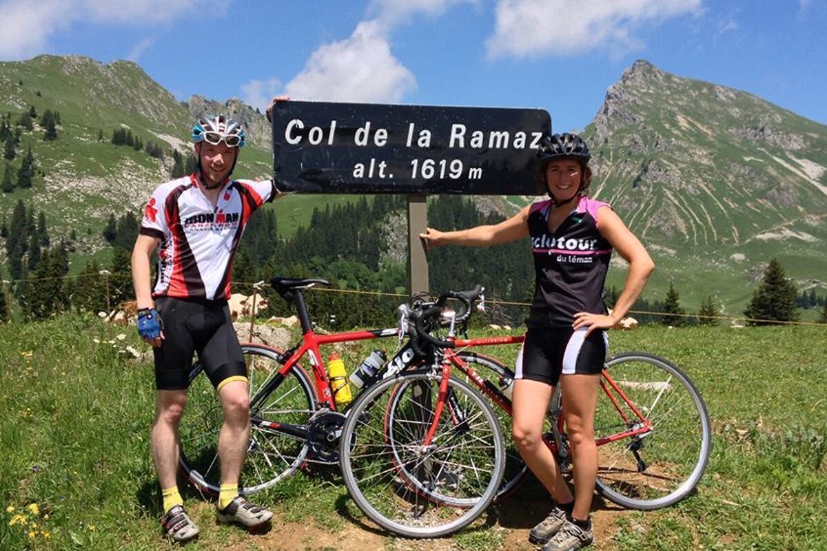 two cyclists at the top of a col near the sign