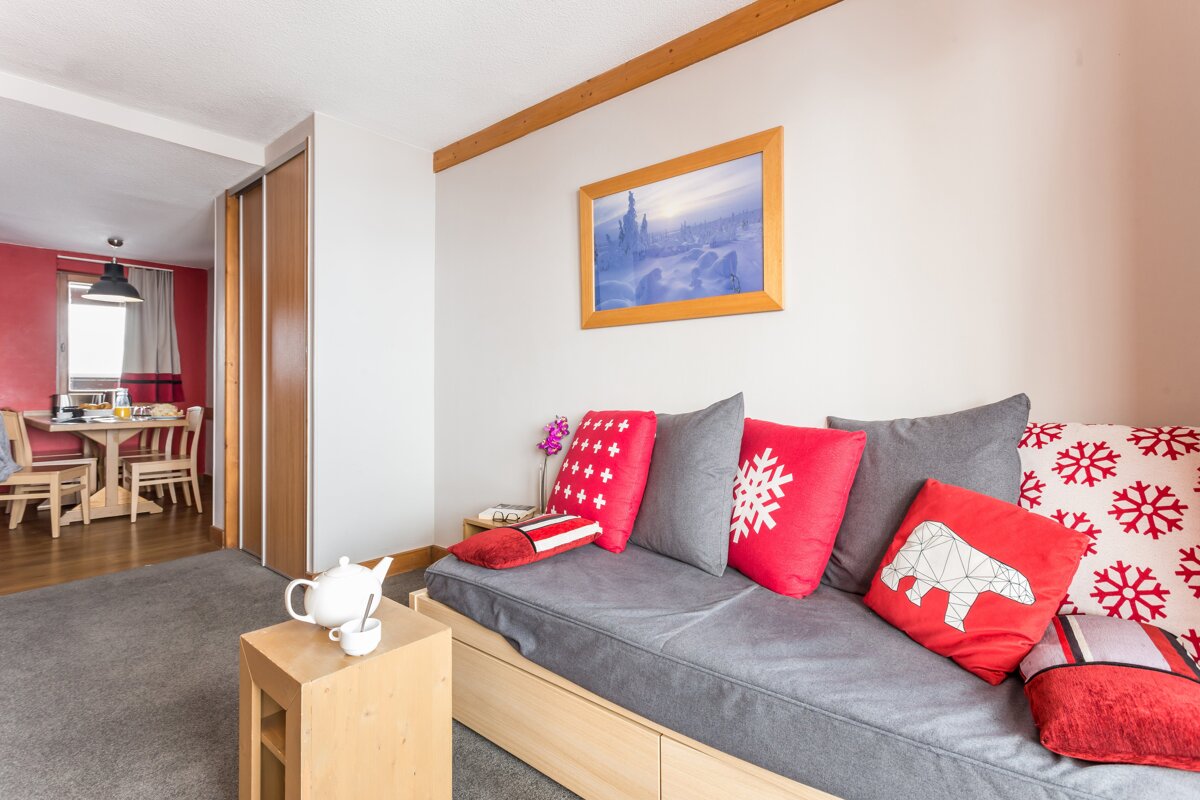 A living room with a couch and pillows and a picture on the wall