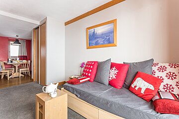 A living room with a couch and pillows and a picture on the wall