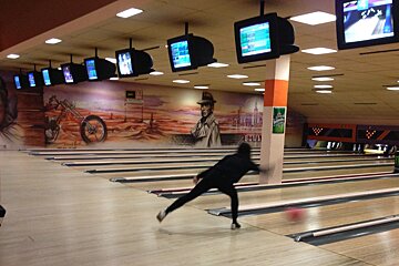 A bowling alley with a green sign that says heineken