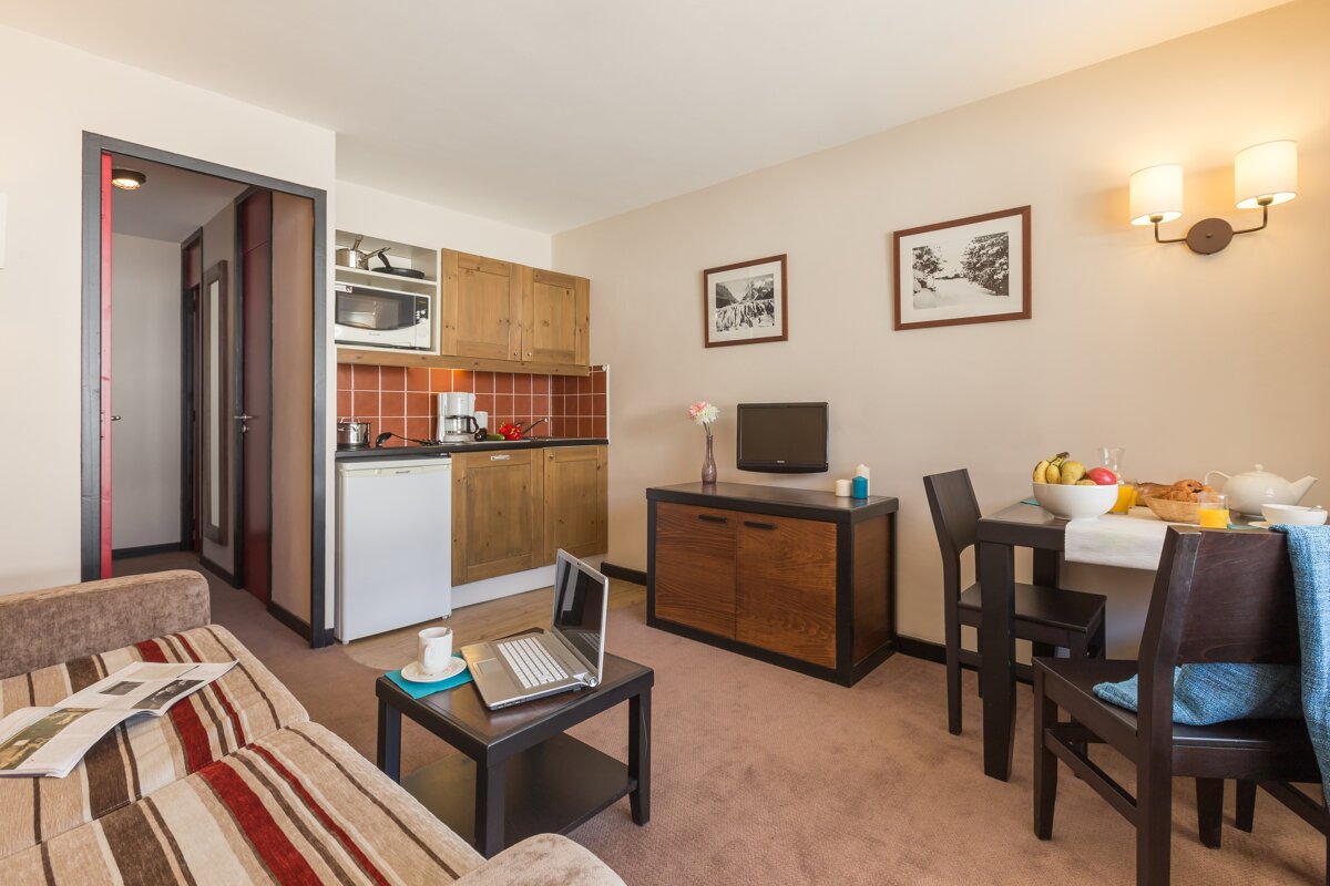 A living room with a couch and a table with a laptop on it