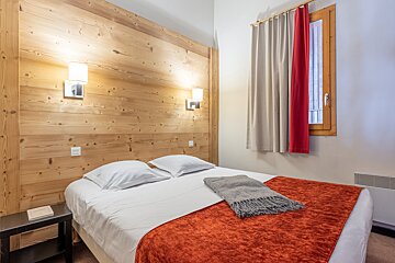 A hotel room with a bed and a window