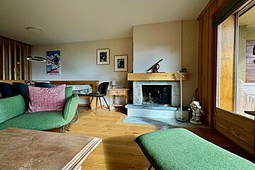 A living room with a fireplace and a ski poster on the wall