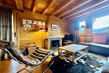 A living room with a fireplace and a picture on the wall that says