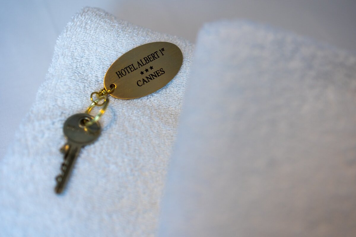 A hotel albert 1 cannes key laying on a white towel