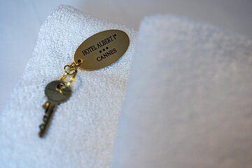 A hotel albert 1 cannes key laying on a white towel