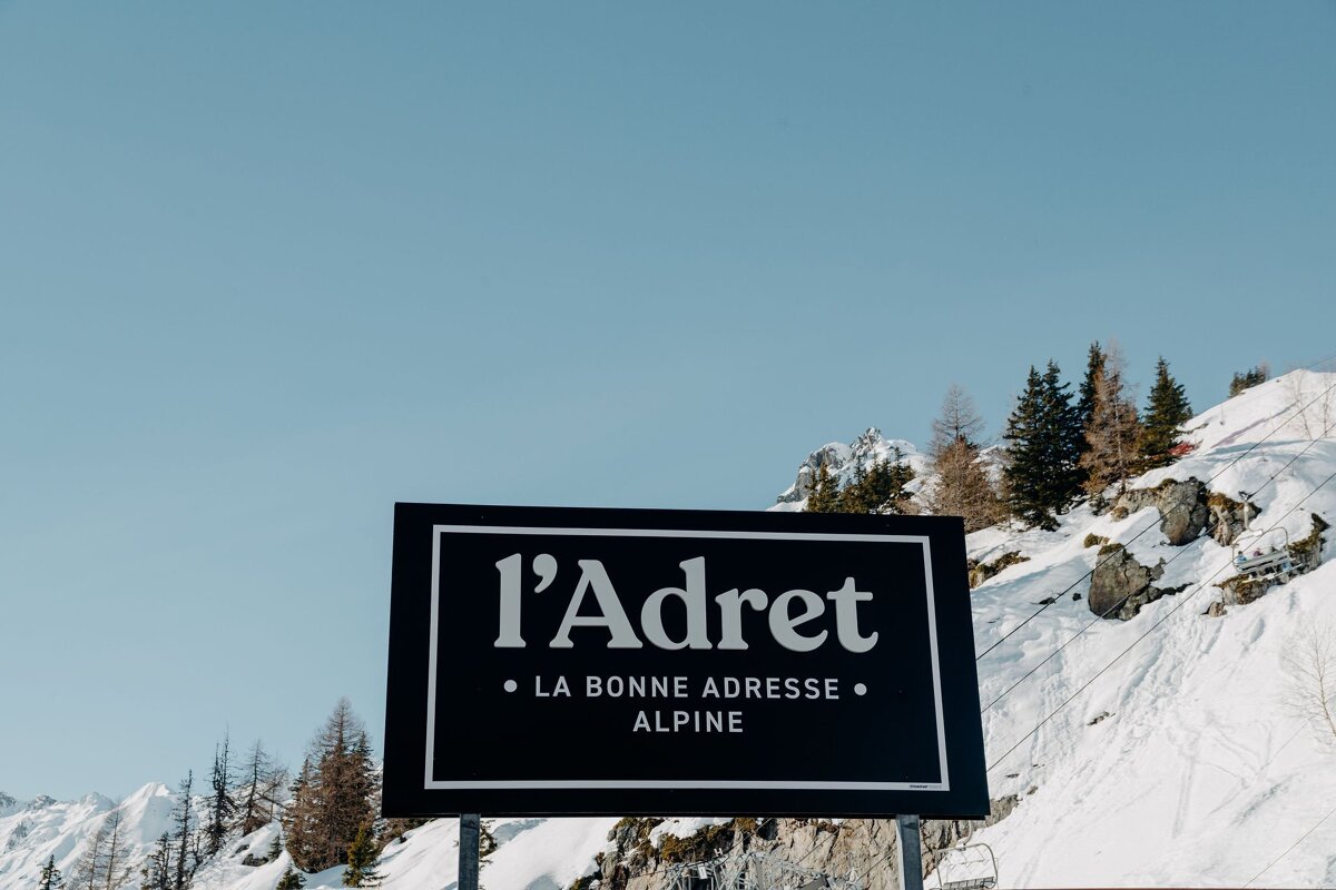 A sign that says l' adret la bonne adresse alpine