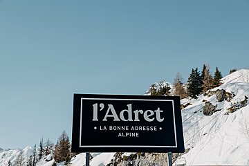 A sign that says l' adret la bonne adresse alpine