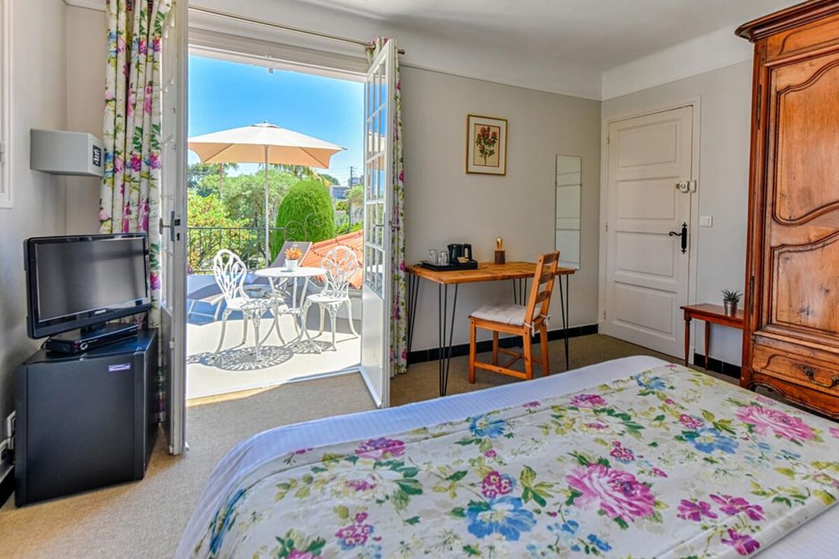 A bedroom with a floral bedspread and a flat screen tv