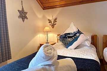 A bed with a blue and white pillow on it