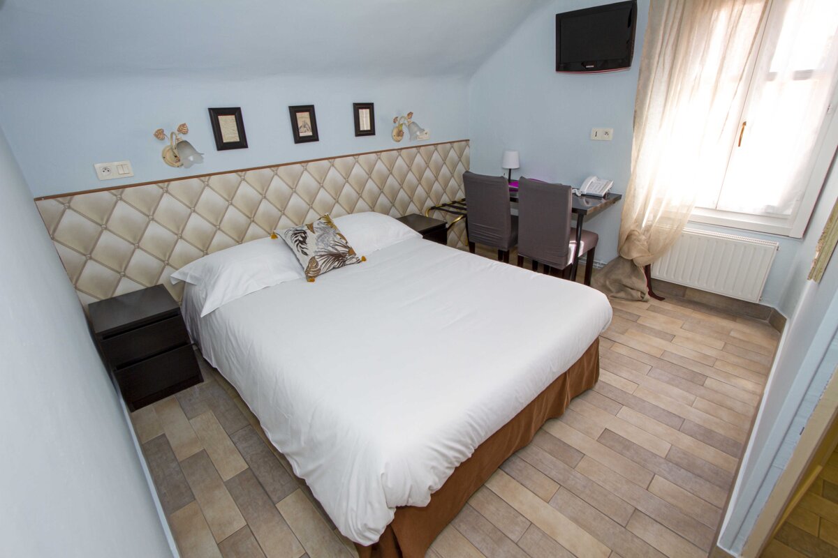 A hotel room with a bed and a desk