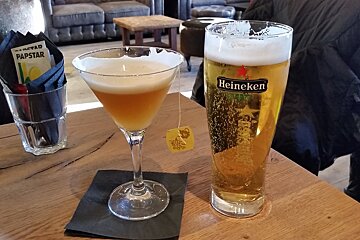 a martini and a beer on a wooden table