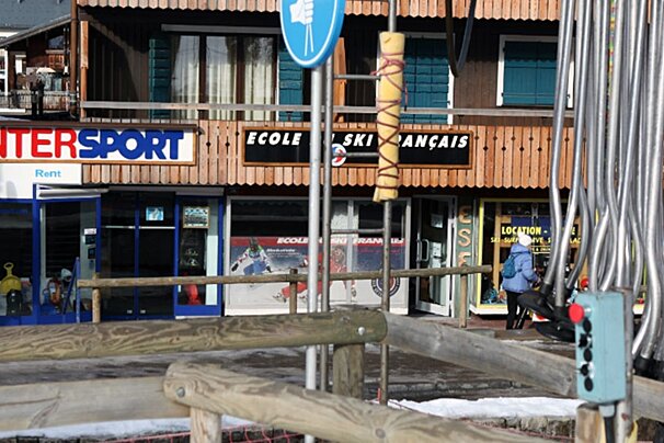 A snowy ski village street with an Intersport shop, 