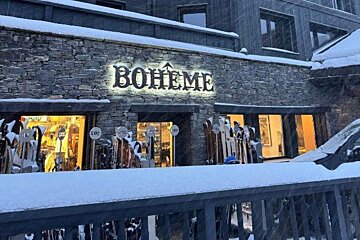 A snow-covered stone building with an illuminated 