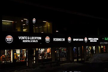 A brightly lit Sport 2000 store at night, advertising
