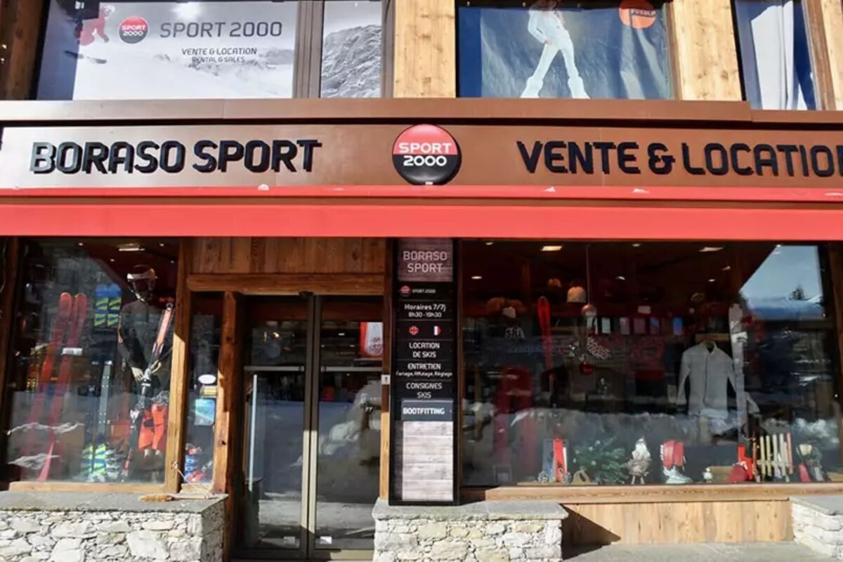 A Sport 2000 Boraso Sport store facade, featuring sales & rentals of ski equipment, with window displays and a red awning.