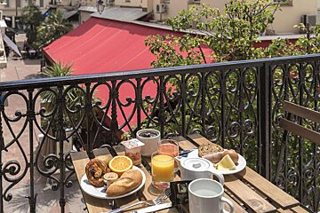 A table with a plate of food and a glass of orange juice