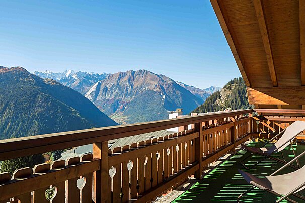 A balcony with chairs and a view of mountains