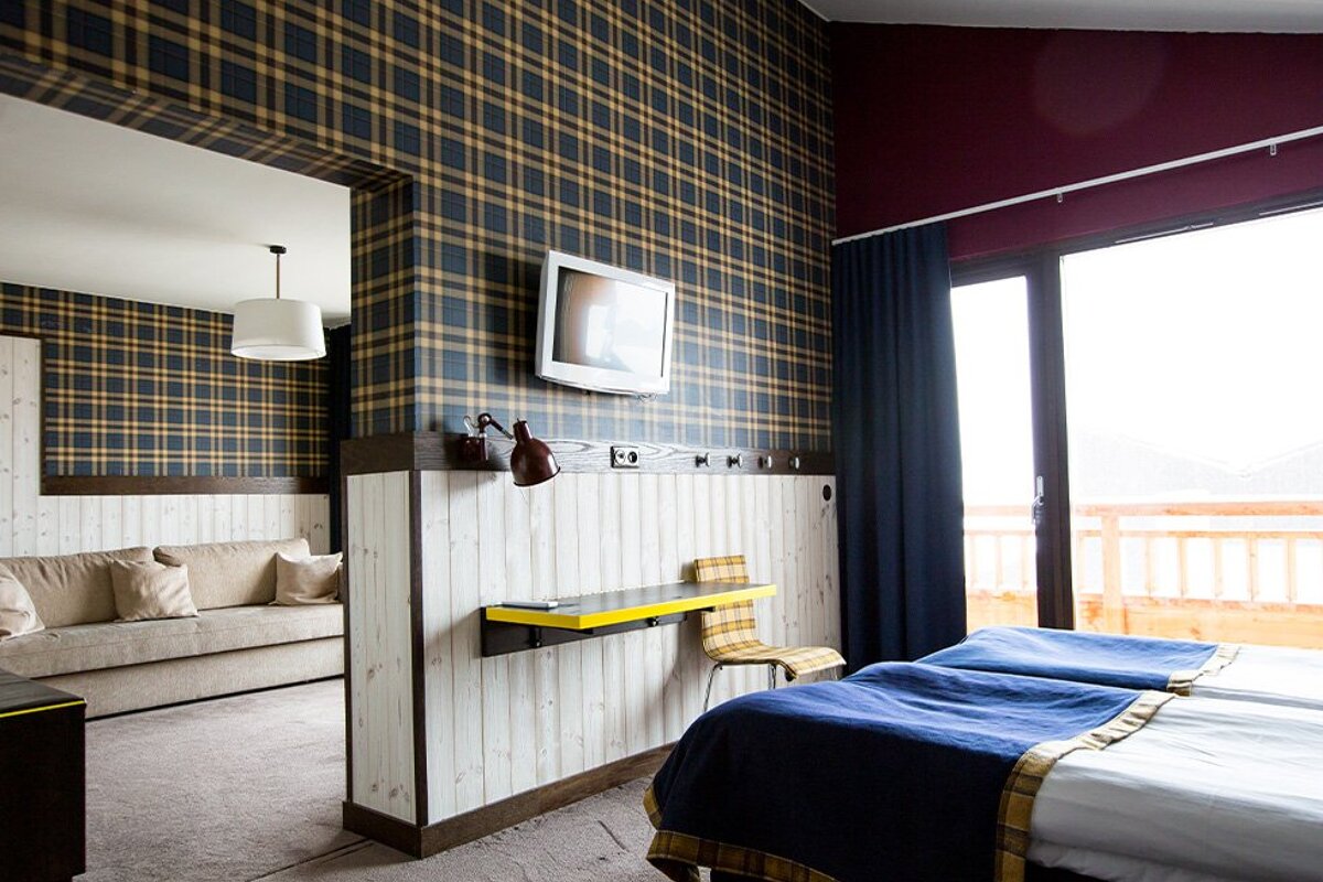 A hotel room with two beds and a flat screen tv