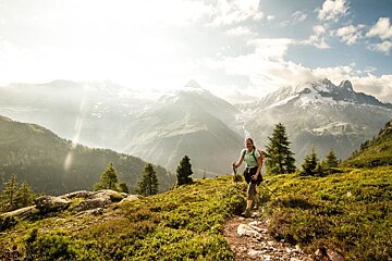 A woman hiking on a trail in the mountains