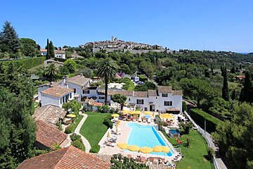An aerial view of a house with a swimming pool in front of it