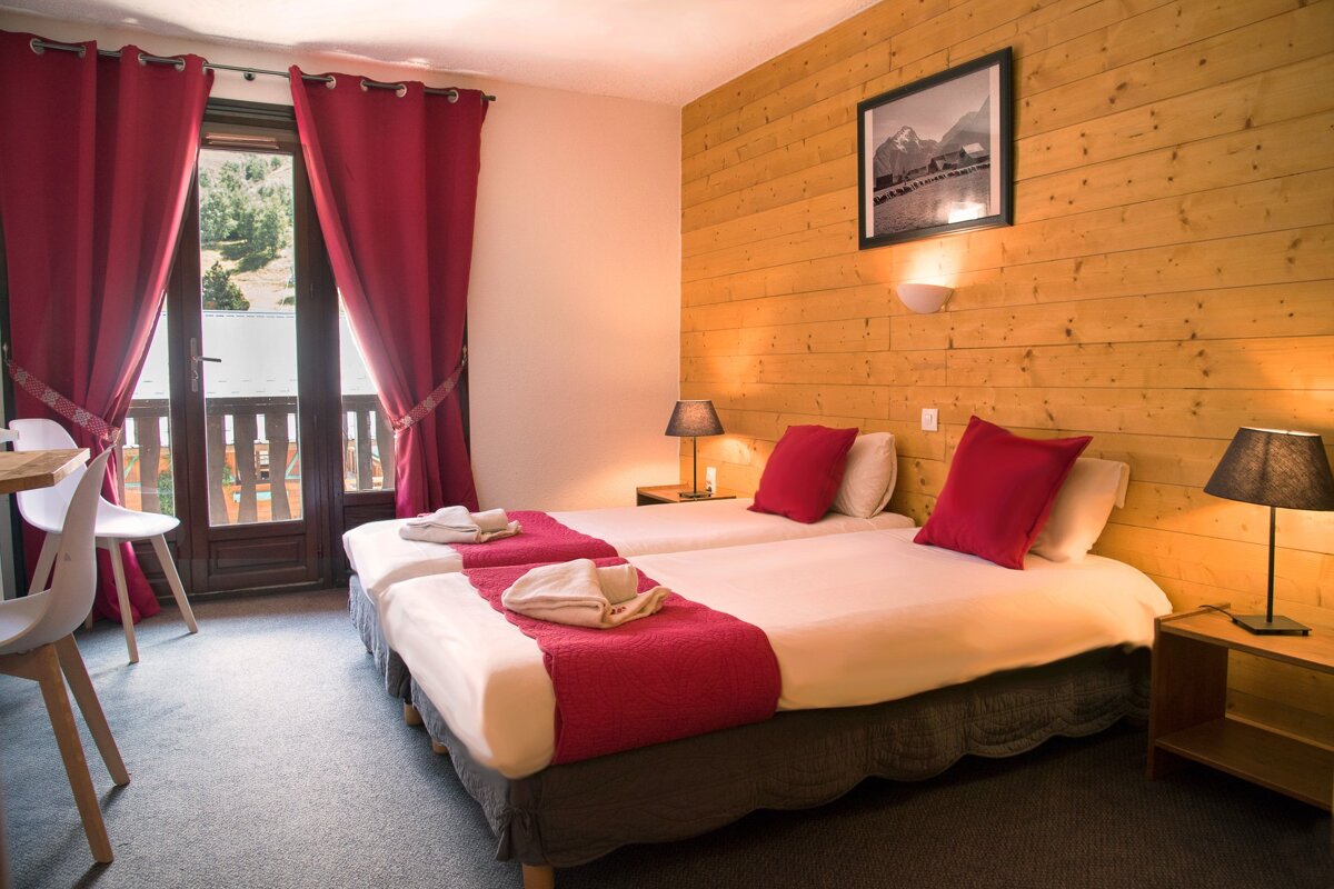 A hotel room with two beds and a picture on the wall